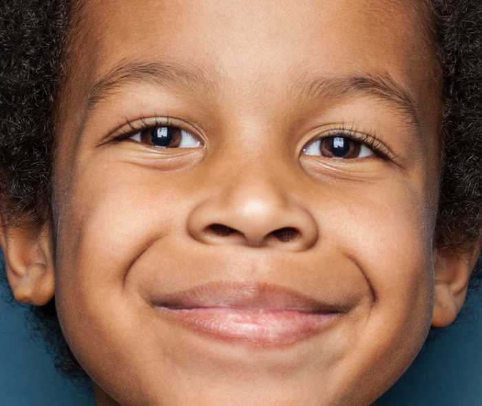 Nahaufnahme vom Gesicht eines Kindes das in die Kamera lächelt