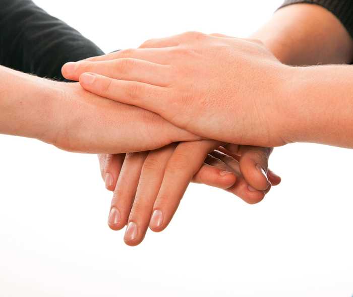 Zwei paar Hände die sich halten