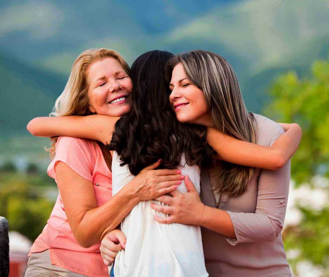 Drei Frauen im mittleren Alter umarmen sich freundschaftlich Drei Frauen im mittleren Alter umarmen sich freundschaftlich